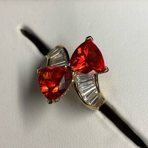 Triangle Orange faceted sapphire and gold tone ring surrounded by baguettes. 7